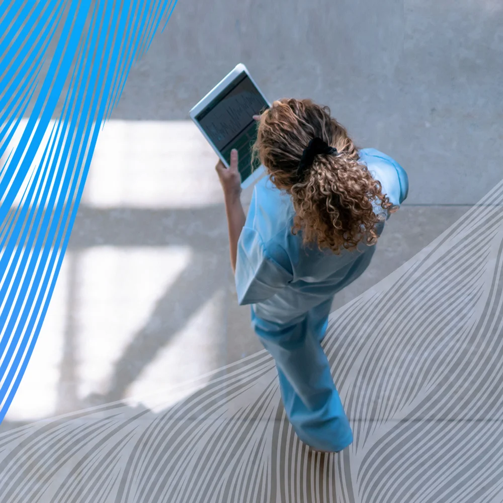 Image of a nurse walking in a hall with a tablet - Square Image of a nurse walking in a hall with a tablet