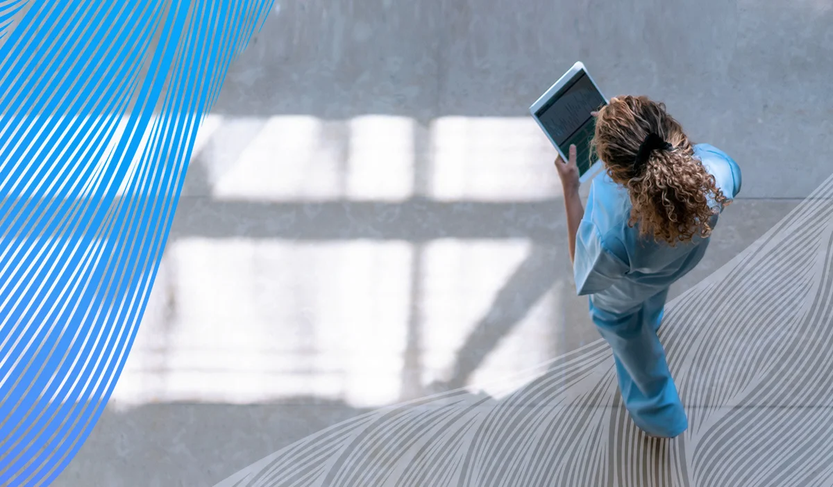 Image of a nurse walking in a hall with a tablet